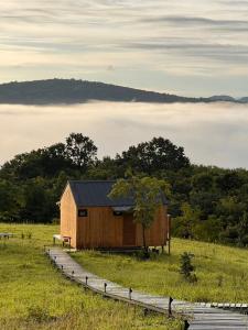 a smallshed in a field with clouds in the background at Hillbilly Farm in Ban Kok Kabok +19 photos
