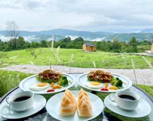 a table with plates of food and two cups of coffee at Hillbilly Farm in Ban Kok Kabok