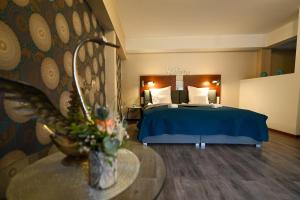 a hotel room with a bed and a table with flowers at Landhotel zum Schwanen mit Restaurant Mona Liza in Osthofen
