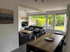 a living room with a table and a couch at De Duinrand in Oostkapelle