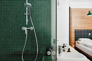 a green tiled bathroom with a shower and a sink at Hotel Daniel Vienna - Smart Lifestyle Near City Centre in Vienna