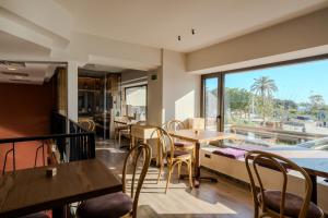 a restaurant with tables and chairs and a large window at Metaxa Hotel Heraklion - Urban Boutique Living in Heraklio