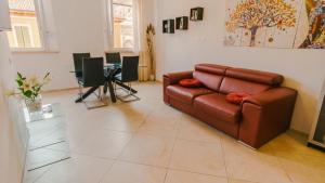 a living room with a brown leather couch and a table at Domus Dantis - Italian Homing in Ravenna