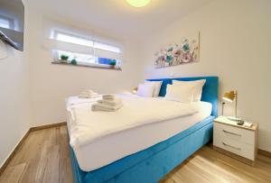 a bedroom with a blue and white bed and a window at VILLA SOLIS LACUS modernes Apartment - privater beheizbarer Pool- Klimaanlage - private Parkplätze in Njivice +40 photos