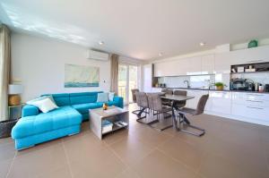 a living room with a blue couch and a table at VILLA SOLIS LACUS modernes Apartment - privater beheizbarer Pool- Klimaanlage - private Parkplätze in Njivice