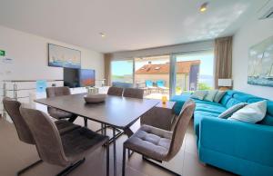 a living room with a blue couch and a table at VILLA SOLIS LACUS modernes Apartment - privater beheizbarer Pool- Klimaanlage - private Parkplätze in Njivice