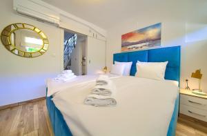 a bedroom with a large bed with towels on it at VILLA SOLIS LACUS modernes Apartment - privater beheizbarer Pool- Klimaanlage - private Parkplätze in Njivice