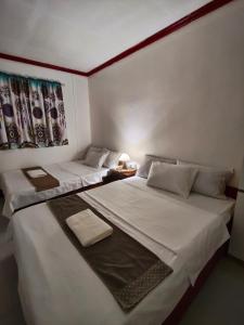 two beds in a small room with at Tugbongan North Siargao in Burgos