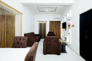 a living room with two chairs and a couch at Famous Apartments in Ologode