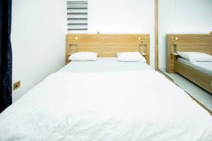 a large white bed in a room with two beds at Famous Apartments in Ologode