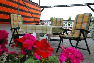 a table and chairs on a patio with pink flowers at Ferienwohnung Braunschweiger Hof in Halberstadt