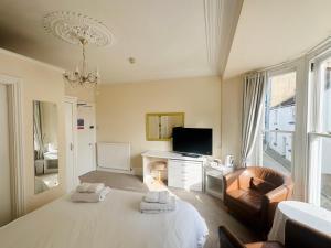 a bedroom with a bed and a desk and a television at Myrtle House Hotel in Tenby