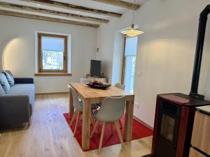 a living room with a wooden table and chairs at Alpine Grace in Falcade