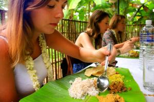 a woman sitting at a table with a plate of food at Hotel White Gate Residency -near to Vaikom Sri Mahadeva Temple in Vaikom