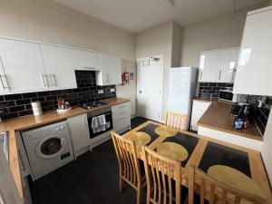 a kitchen with a table and chairs in a kitchen at Prime Dundee West End 3BR Apartment, Stunning River Views, Sleeps 6 in Dundee