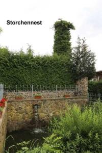 a stone wall with a water fountain in a garden at Fewos Storchenhof am Kummerower See in Meesiger +23 photos