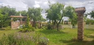 a garden with a brick pillar in the grass at Fewos Storchenhof am Kummerower See in Meesiger