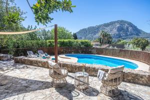 a patio with chairs and a swimming pool at Can Miquel, villa in Pollensa in Pollença