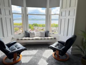 a living room with two chairs and a large window at Prime Dundee West End 3BR Apartment, Stunning River Views, Sleeps 6 in Dundee