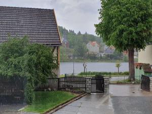 a house with a fence in front of a lake at Ferienwohnung Wagner in Stiege