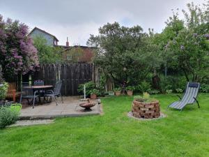 a backyard with a table and chairs and a fire pit at Ferienwohnung Wagner in Stiege