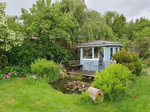 a small house in a garden with a pond at Ferienwohnung Wagner in Stiege +20 photos