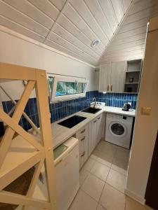 a small kitchen with a washer and dryer at Mini Apart - Gdańsk Jelitkowo in Gdańsk