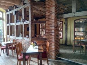a dining room with tables and chairs and a brick wall at Scheunen-Domizil in Bollewick +18 photos