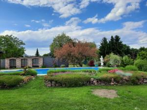 a garden with a swimming pool and flowers at Ferienwohnung im Spreewald - Natur Pur in Lübben