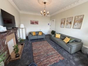a living room with two couches and a fireplace at Prime Dundee West End 3BR Apartment, Stunning River Views, Sleeps 6 in Dundee