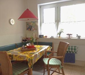 a dining room table with chairs and a red lamp at Fewo Apfel Striep in Steinkirchen +2 photos