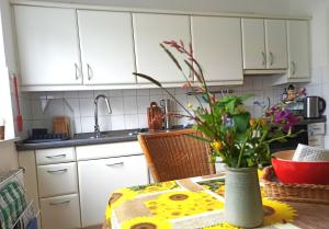 a kitchen with a table with a vase of flowers at Fewo Apfel Striep in Steinkirchen