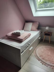 a small bedroom with a bed with a window at B&B 't Herfter Erf in Zwolle