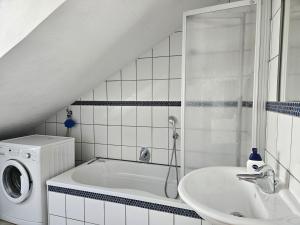 a bathroom with a sink and a washing machine at Ferienwohnung Wartturmblick in Nierstein