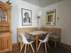 a dining room with a table and white chairs at Ferienwohnung Wartturmblick in Nierstein