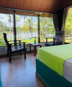 a bedroom with a bed and a view of the water at Jungle Lake View Cabana in Udawalawe