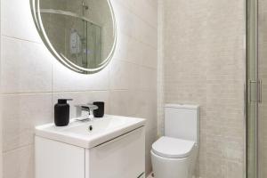 a white bathroom with a sink and a mirror at Modern City Centre Ground Floor - Apt 6 in Bradford +13 photos