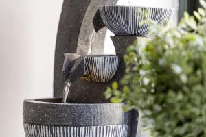 a bird feeder with three tiers of water coming out of it at Modern City Centre Ground Floor - Apt 6 in Bradford