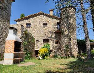 an old stone house with a chimney on the side of it at Can Canals (Rectoria de Dosquers) in Maia de Montcal