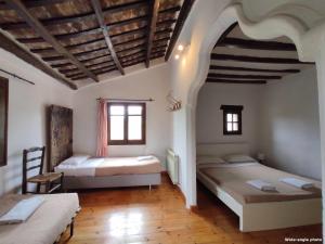 a bedroom with two beds and a wooden floor at Can Canals (Rectoria de Dosquers) in Maia de Montcal +31 photos