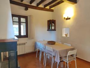 a dining room with a table and chairs at Can Canals (Rectoria de Dosquers) in Maia de Montcal