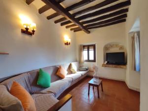 a living room with a couch and a tv at Can Canals (Rectoria de Dosquers) in Maia de Montcal