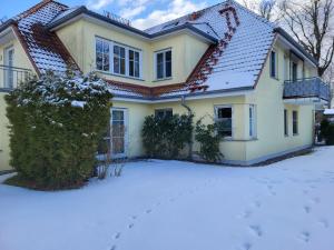 a house with snow on the ground at An der Schmiedestraße Strandläufer in Wustrow