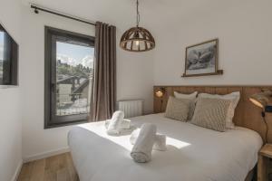 a bedroom with a white bed with towels on it at Alpine Blanc - Neuf, calme & Wellness in Saint-Gervais-les-Bains +13 photos