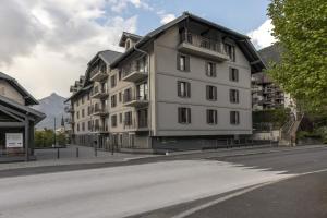 a large white building on the side of a street at Alpine Blanc - Neuf, calme & Wellness in Saint-Gervais-les-Bains