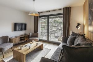 a living room with a couch and a table at Alpine Blanc - Neuf, calme & Wellness in Saint-Gervais-les-Bains