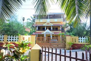 a house with a fence in front of it at Kannur Beach view Homestay in Kannur