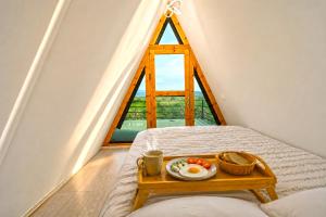 a breakfast tray on a bed in a room with a window at Villa Olivia in Elbasan