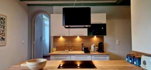 a kitchen with a sink and a tv hanging from the ceiling at A La Bruyère in Saint-Martin-du-Lac +10 photos