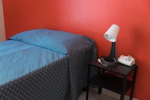 a bedroom with a bed and a lamp on a nightstand at VMHostel in Montecatini Terme +23 photos